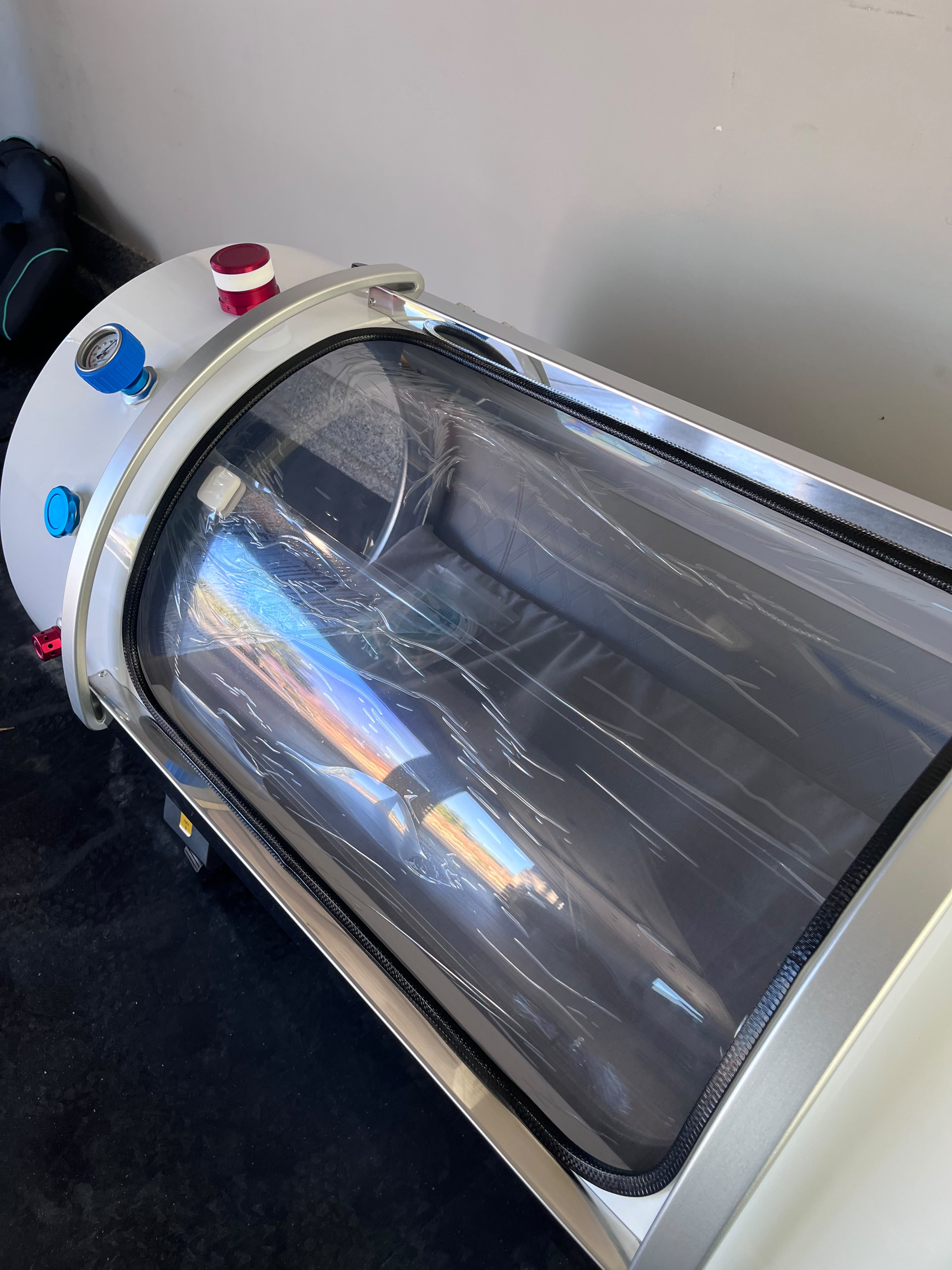 A close view of the hardshell chamber's curved viewing window and exterior controls