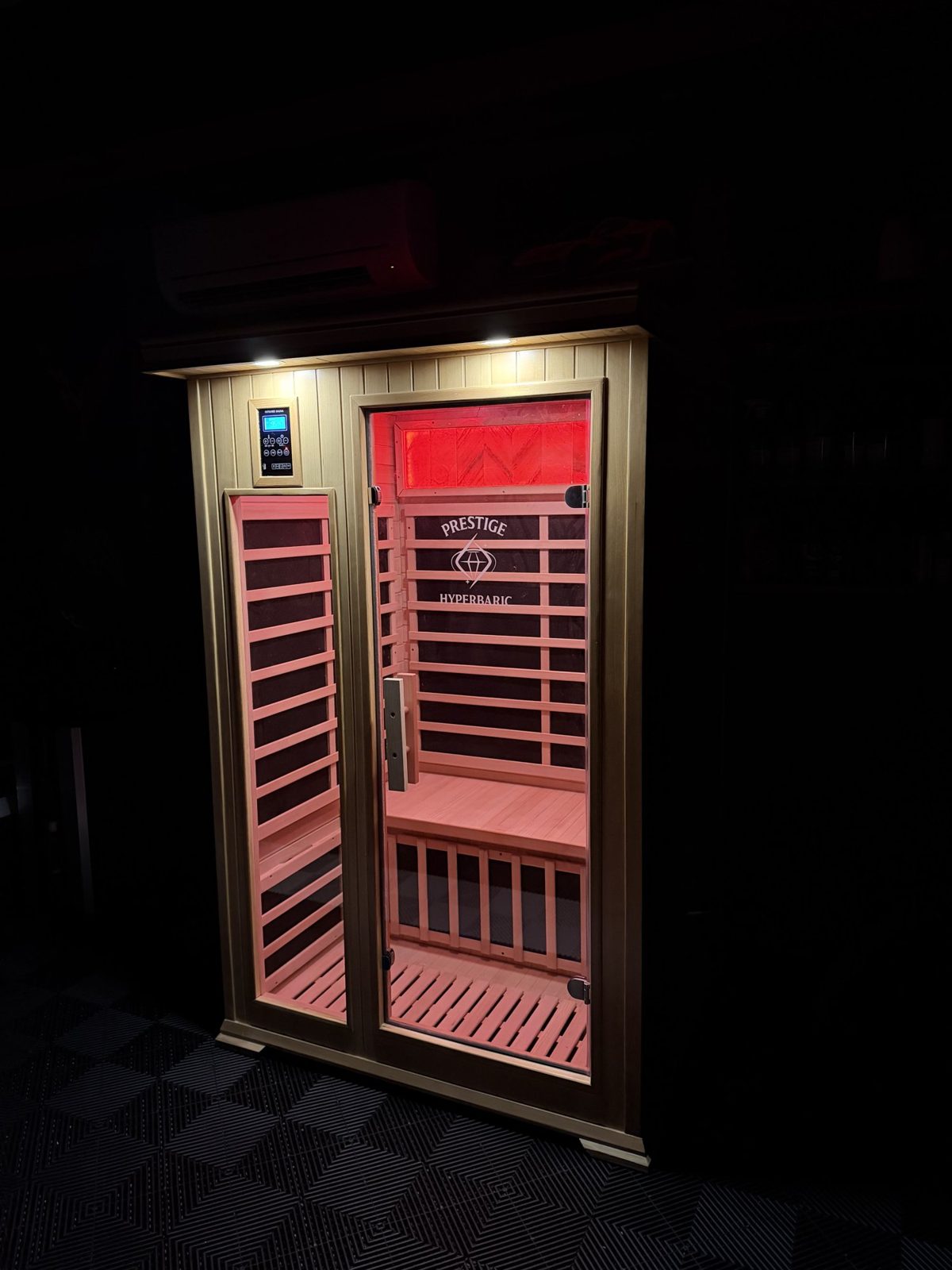 Classic Carbon Duo Sauna glowing with the room lights down