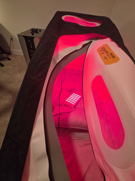 Red light panel inside Eugene's soft shell chamber, viewed through the open zipper
