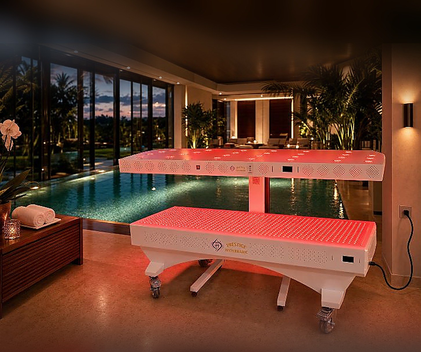 Prestige Pro red light therapy bed illuminated beside a poolside lounge